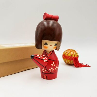 Bambola Kokeshi in legno Amayadori dipinta in una statuetta rossa, bianca e marrone
