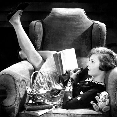Frau im großen Stuhl liest leere Grußkarte des Buches