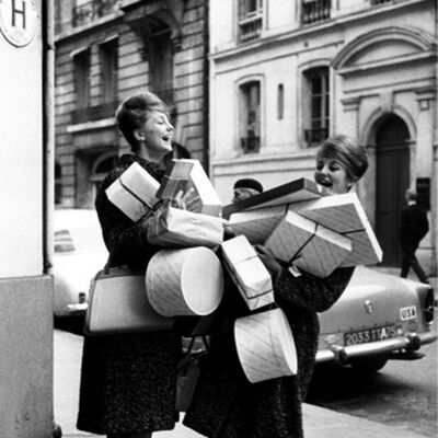 Dos mujeres de compras con cajas de tarjetas de felicitación en blanco
