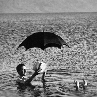 Hombre en agua con paraguas y libro tarjeta de saludos en blanco