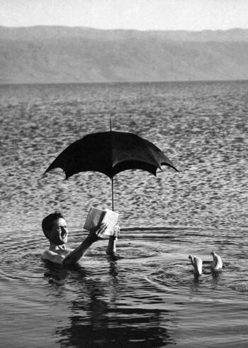 Homme dans l'eau avec parapluie et carte de voeux vierge de livre