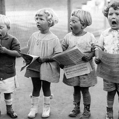 Niños cantando tarjetas de felicitación en blanco