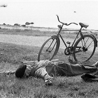 Uomo che dorme accanto alla cartolina d'auguri in bianco della bici