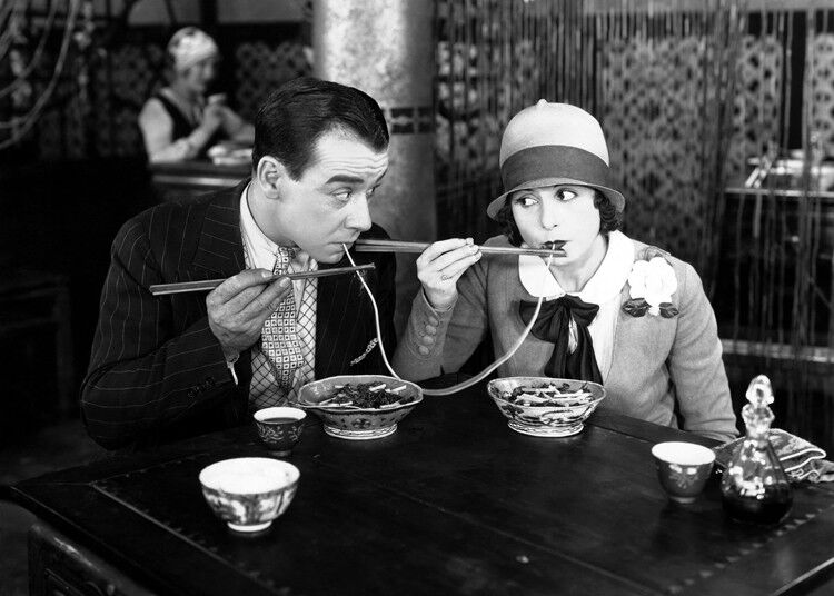 Coppie che mangiano la cartolina d'auguri in bianco degli spaghetti