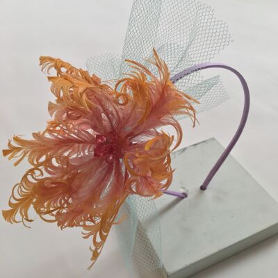 Pink and yellow feather flower with net on a lilac silk headband.
