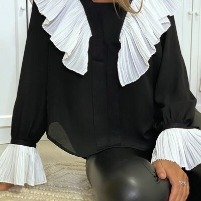 Blouse en crêpe noir pour femme avec volant plissé en blanc.