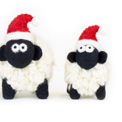 Pecora di montagna in piedi in lana lavorata a maglia con cappello da Babbo Natale piccolo