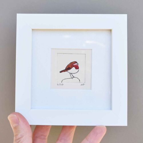 Robin on a rock facing right - mini collagraph print in a white frame