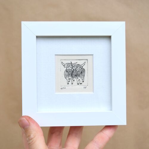 Two highland cows standing close - mini collagraph print in a white frame