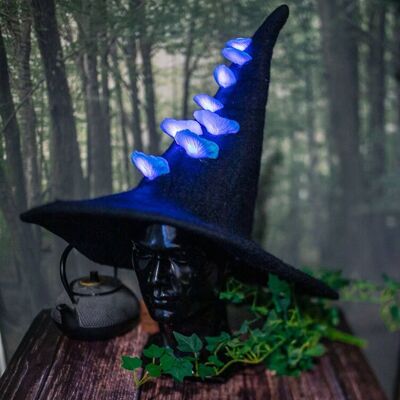Sombrero de bruja negra, setas azules que brillan intensamente, luces, fantasía__