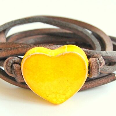 Pulsera de cuero con corazón de cerámica amarilla.