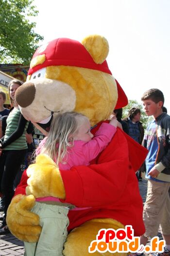 Costume de mascotte personnalisable de gros ours jaune et rouge avec une casquette.
