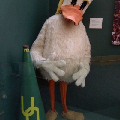 Costume de mascotte personnalisable de canard blanc et orange, avec des cheveux jaunes.