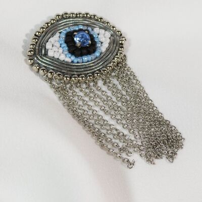 Broche ojo bordado con perlas y cadenas de plata.