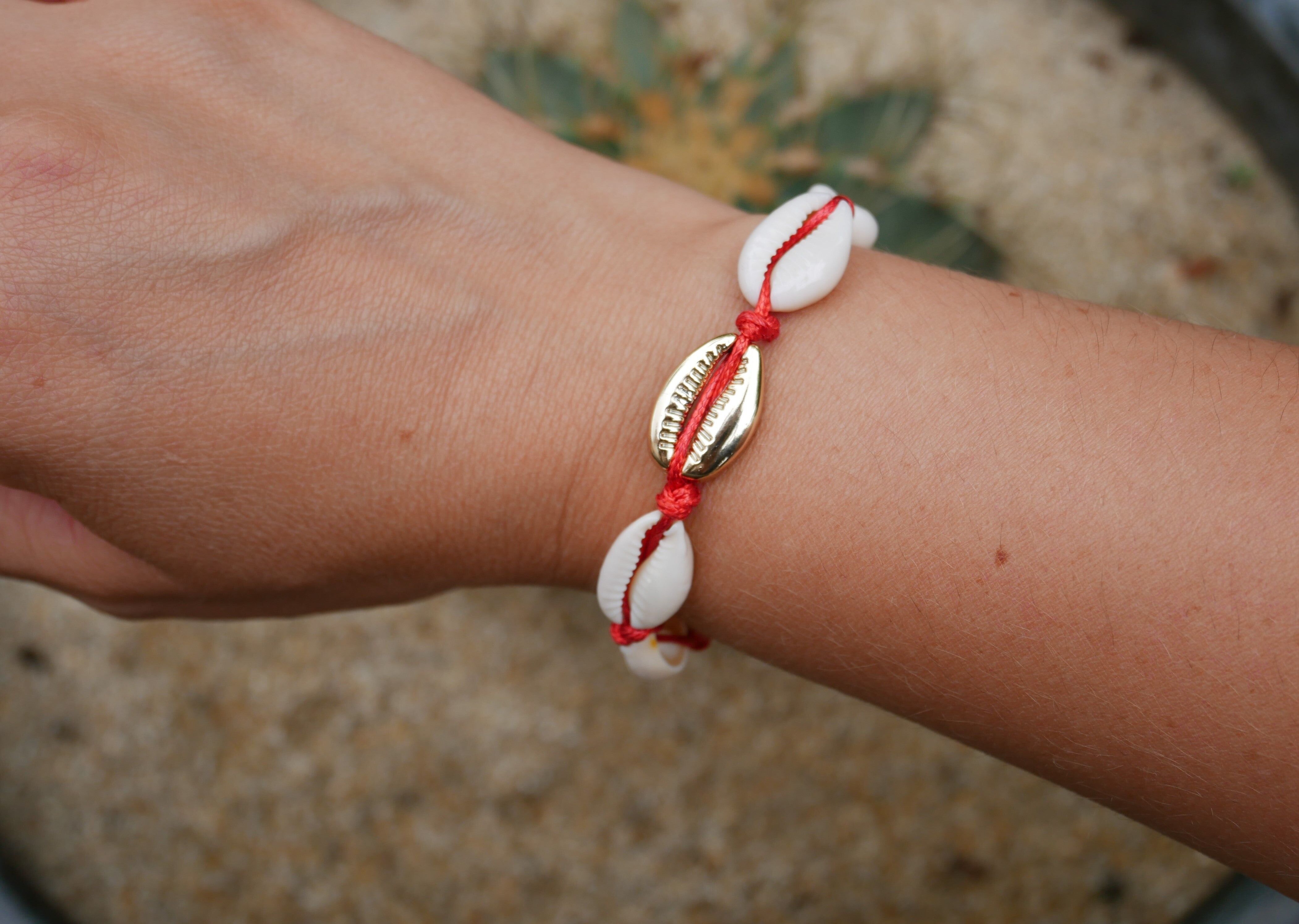 Rotes Armband aus natürlichen Kaurimuscheln und einer goldenen Kauri