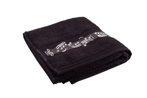 schwarzes Handtuch mit eingewebter Notenbordüre und Notenschlüssel in der Mitte