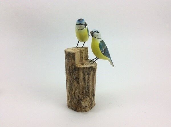 Due cinciallegre su un tronco d'albero di legno nei colori blu e giallo