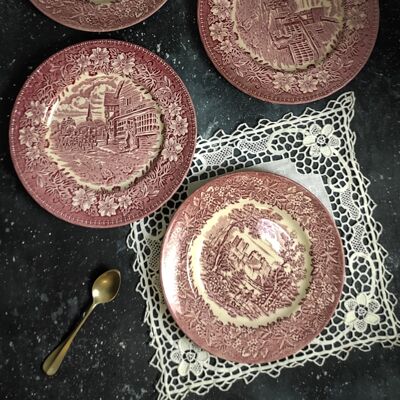 Four red dessert plates with different designs