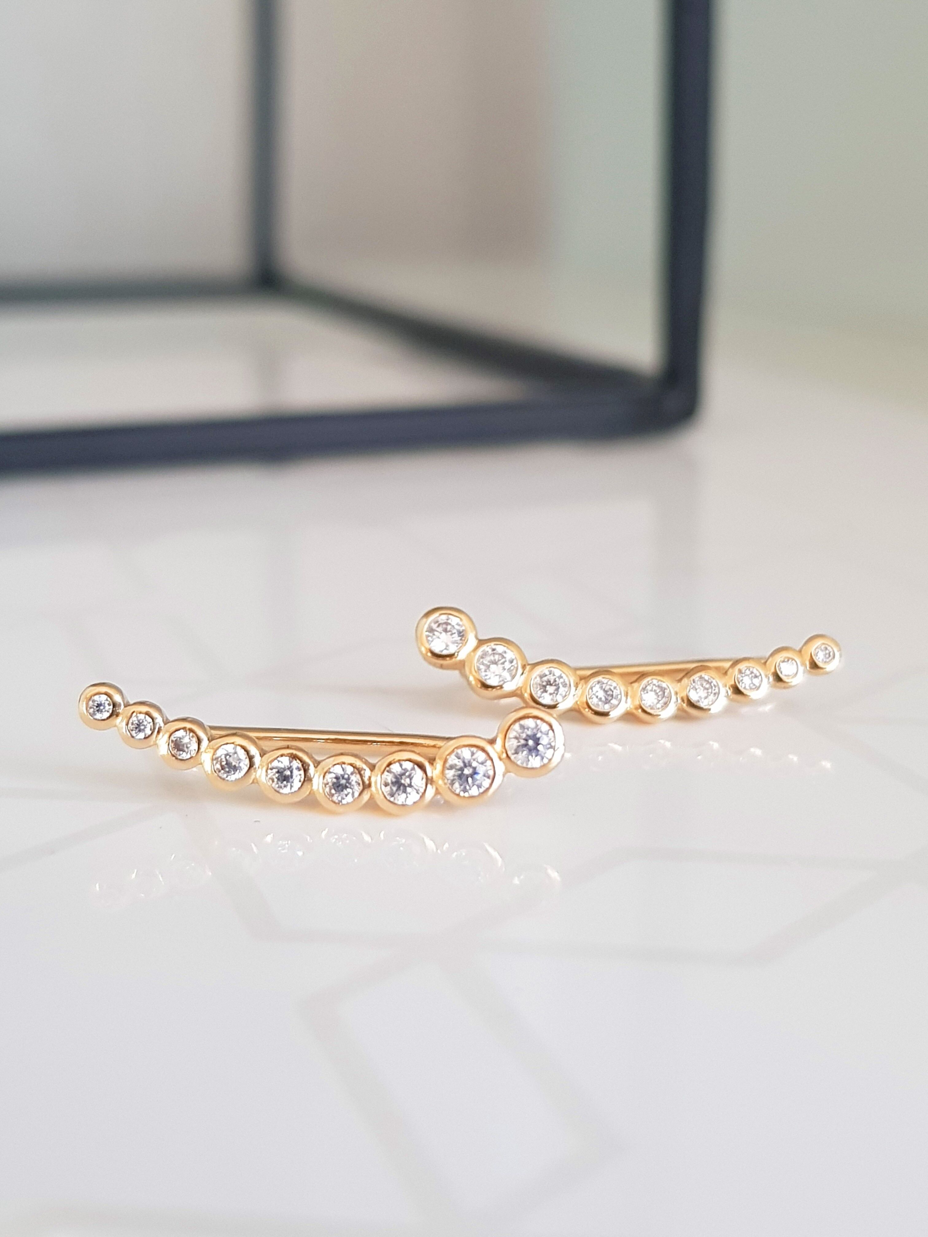 Ohrringe "Ohrkonturen" in vergoldeten und Lünette besetzten weißen Zirkonoxiden