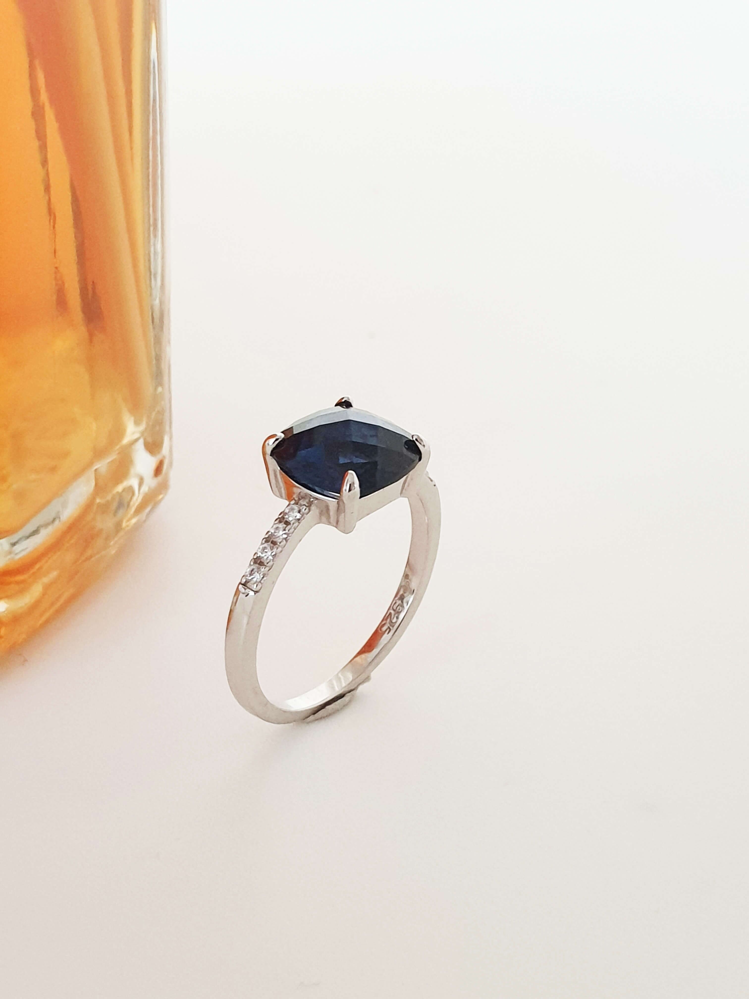 Ring aus Silber rhodiniert 925/1000 mit Zirkonoxiden, gekrönt von einem Quadrat aus facettiertem marineblauem synthetischem Stein