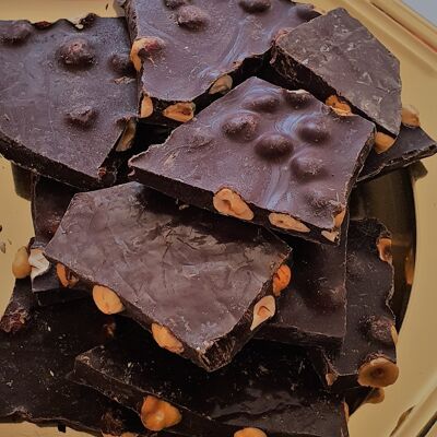 broken slabs of dark chocolate with bulk hazelnuts - organic