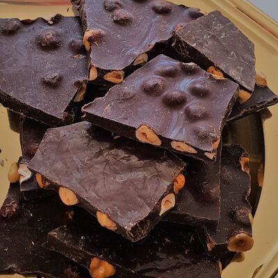 broken slabs of dark chocolate with bulk hazelnuts - organic