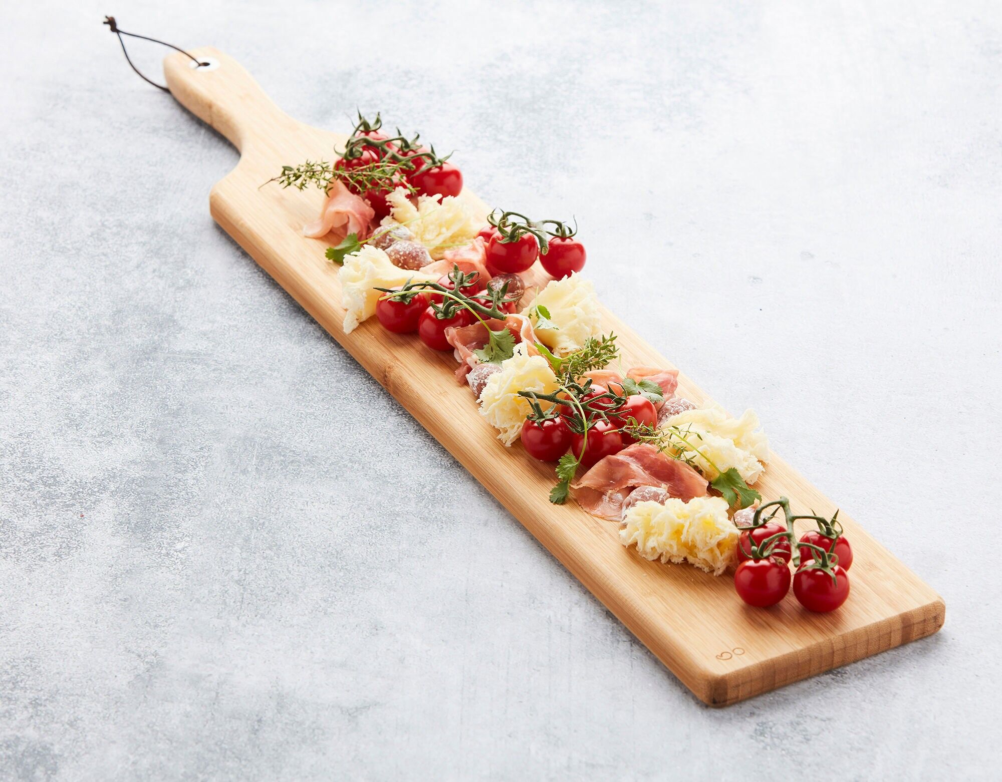 Tavola di bambù con anello in metallo e cordino in pelle FSC 75x14x1,9 cm