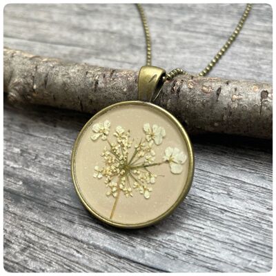 Necklace with real wild carrot flowers in sand