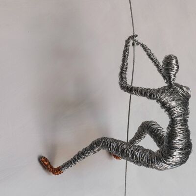 Escultura de hombre trepador con zapatos de cobre