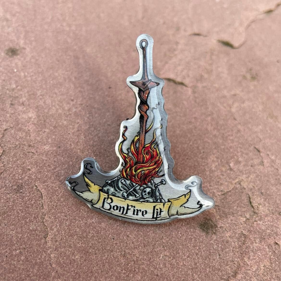 Insignia de metal con hoguera encendida