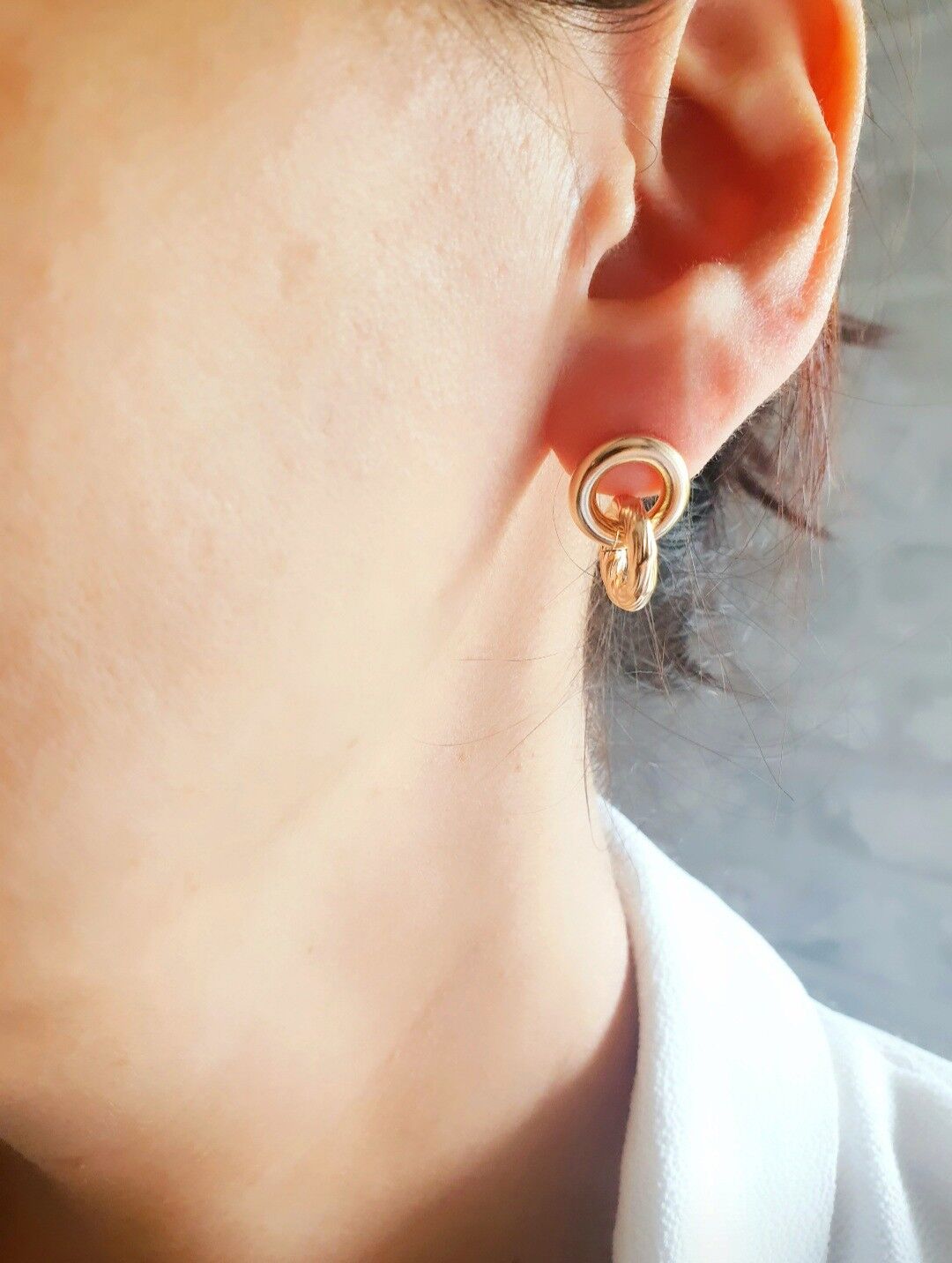 Orecchini con 2 anelli intrecciati, uno liscio e l'altro a coste, con borchie