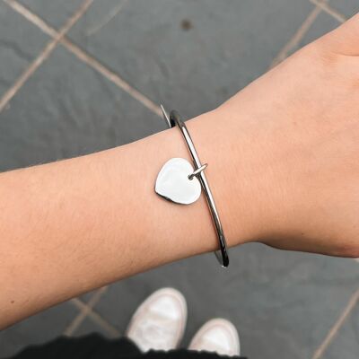 Brazalete de acero con borlas en forma de corazón