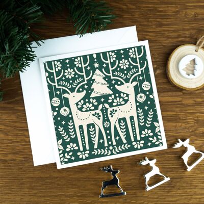 Cartolina di Natale nordica di lusso: le renne, cervi chiari su sfondo verde