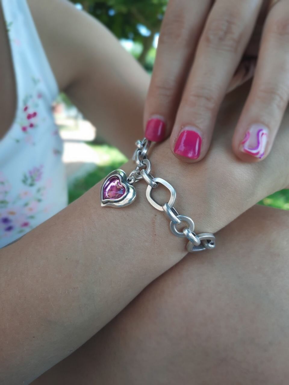 Bracciale a catena irregolare con cuore colorato.