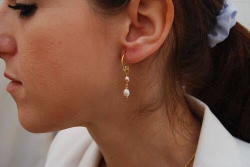 Silver hoops earrings with pearls.