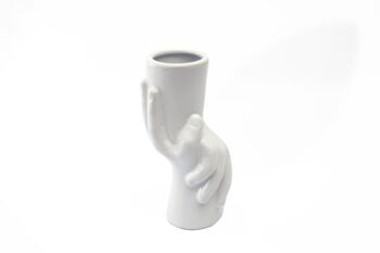 Petit vase en céramique tenant par la main