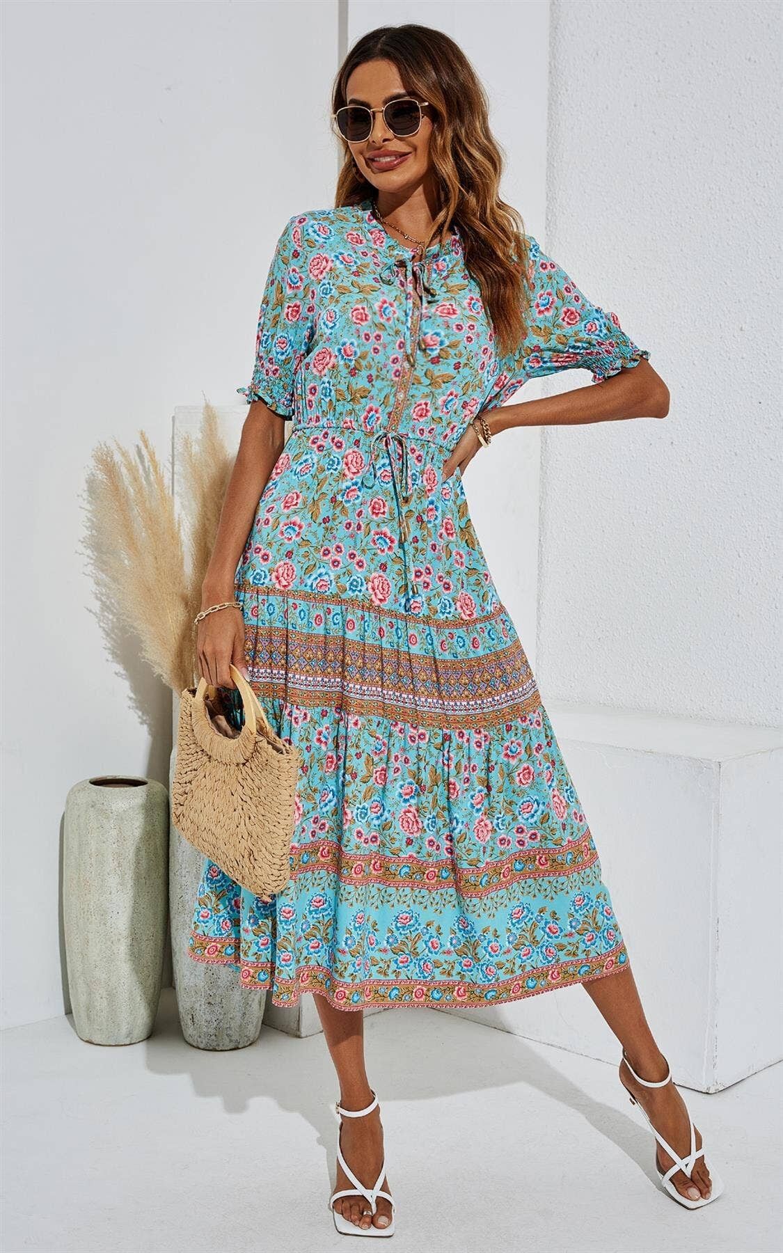 Abito longuette a balze rosa con stampa floreale e collo annodato in blu turchese