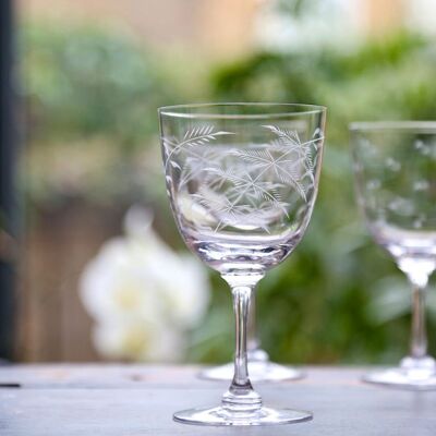 Un par de copas de vino de cristal con diseño de helecho