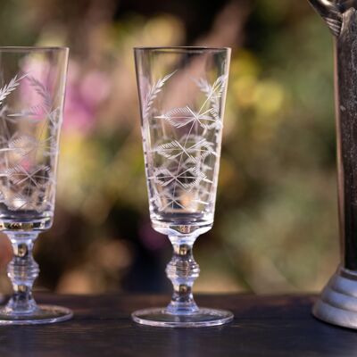 Un juego de cuatro copas de champán de cristal con diseño de helecho