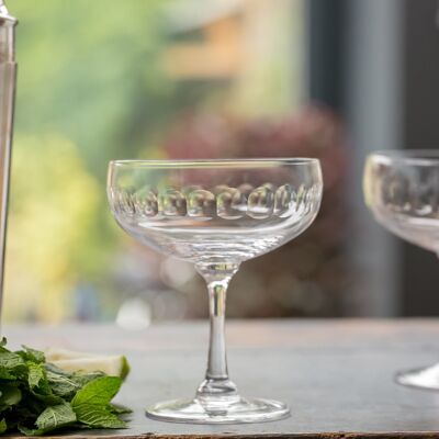 Un set di quattro bicchieri da cocktail in cristallo con design a lente