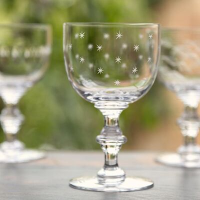 Un ensemble de quatre verres à vin en cristal avec motif étoiles