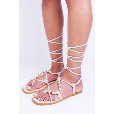 Sandalia de tiras con plataforma plana de poliuretano color crema con cuentas y lazo en la pierna
