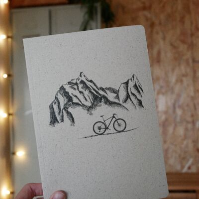 Diario de viaje de papel de hierba montañas y bicicleta