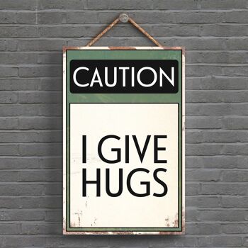 P1532 - Caution I Give Hugs Typography Sign Imprimé sur une plaque à suspendre en bois 1