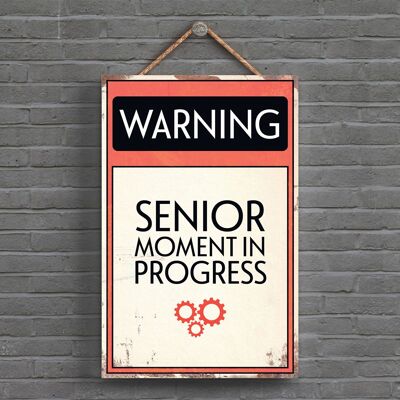 P1605 – Warning Senior Moment In Progress Typografie-Schild, gedruckt auf einer hölzernen Hängeplakette