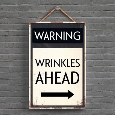 P1613 – Warning Wrinkles Ahead Typografie-Schild, gedruckt auf einer hölzernen Hängeplakette
