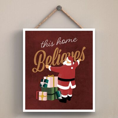 P2553 - This Home Believes Santa With Presents Typography On An Off Square Shaped Wooden Hanging Plaque
