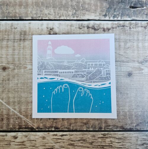 Swimmers View - Blank greeting card of a swimmers feet looking back towards the shore with a lighthouse