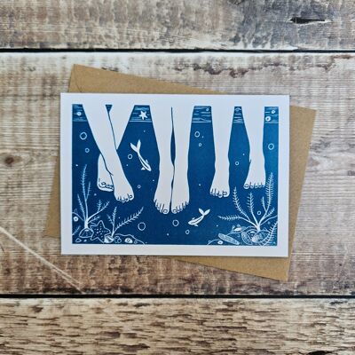 Seaside - Blank greeting card of three pairs of legs paddling in the sea