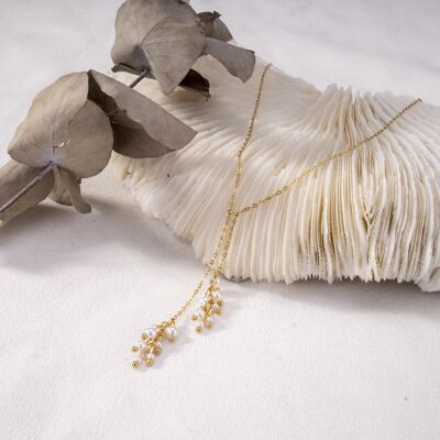 Goldene Halskette mit baumelnden Perlen